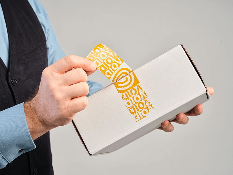 Sustainable & secure packaging: Peeling a brown PaperVOID Stripe from a white cardboard box.